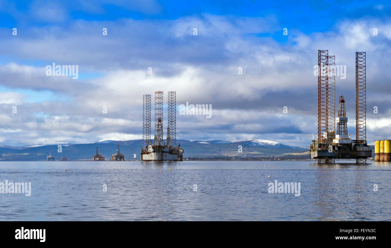 NORTH SEA OIL RIGS UNDER REPAIR IN THE CROMARTY FIRTH WITH SNOW CAPPED HILLS AND INVERGORDON IN THE DISTANCE Stock Photo