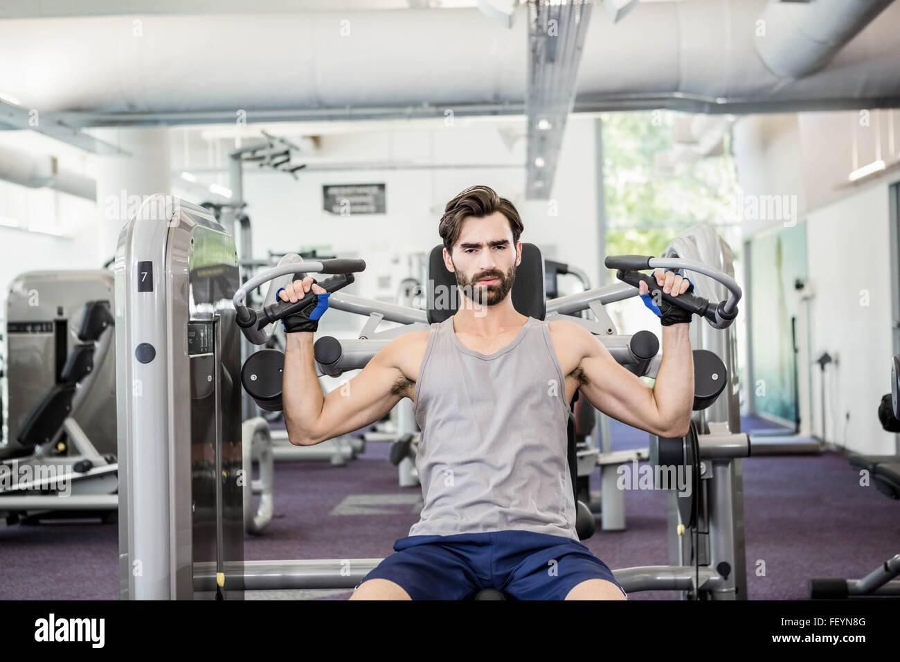 Focused man using weights machine for arms Stock Photo Alamy