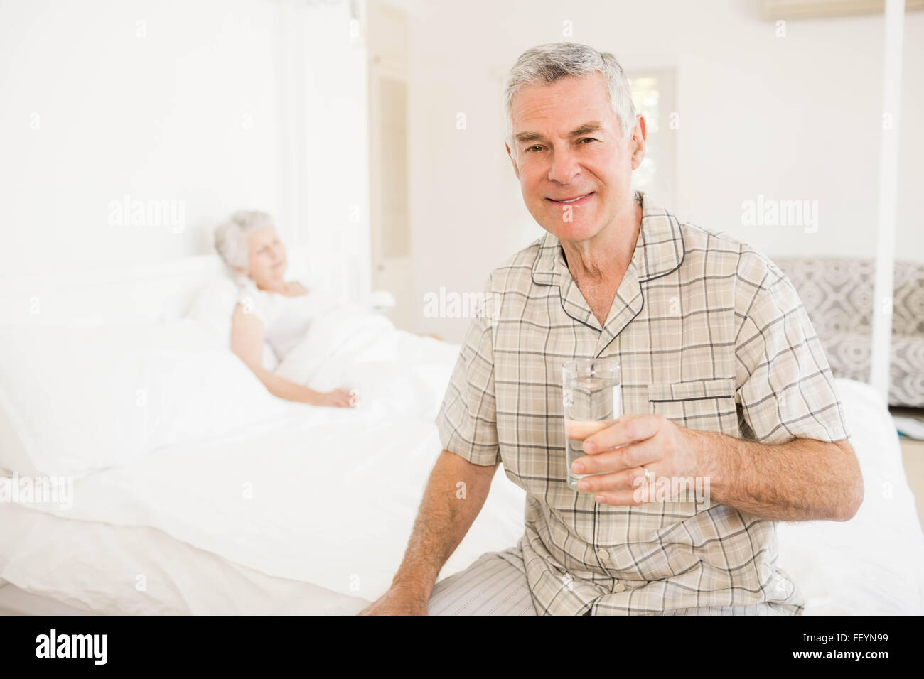 Peaceful senior man holding glass of water Stock Photo - Alamy