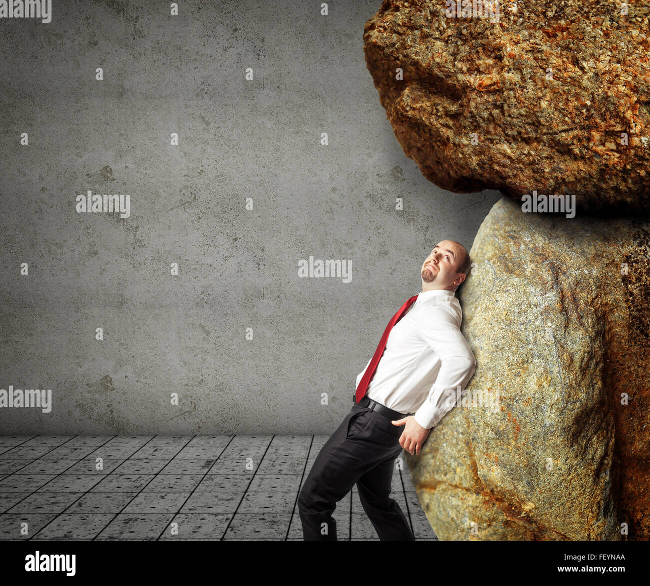 businessman try to move huge stones Stock Photo