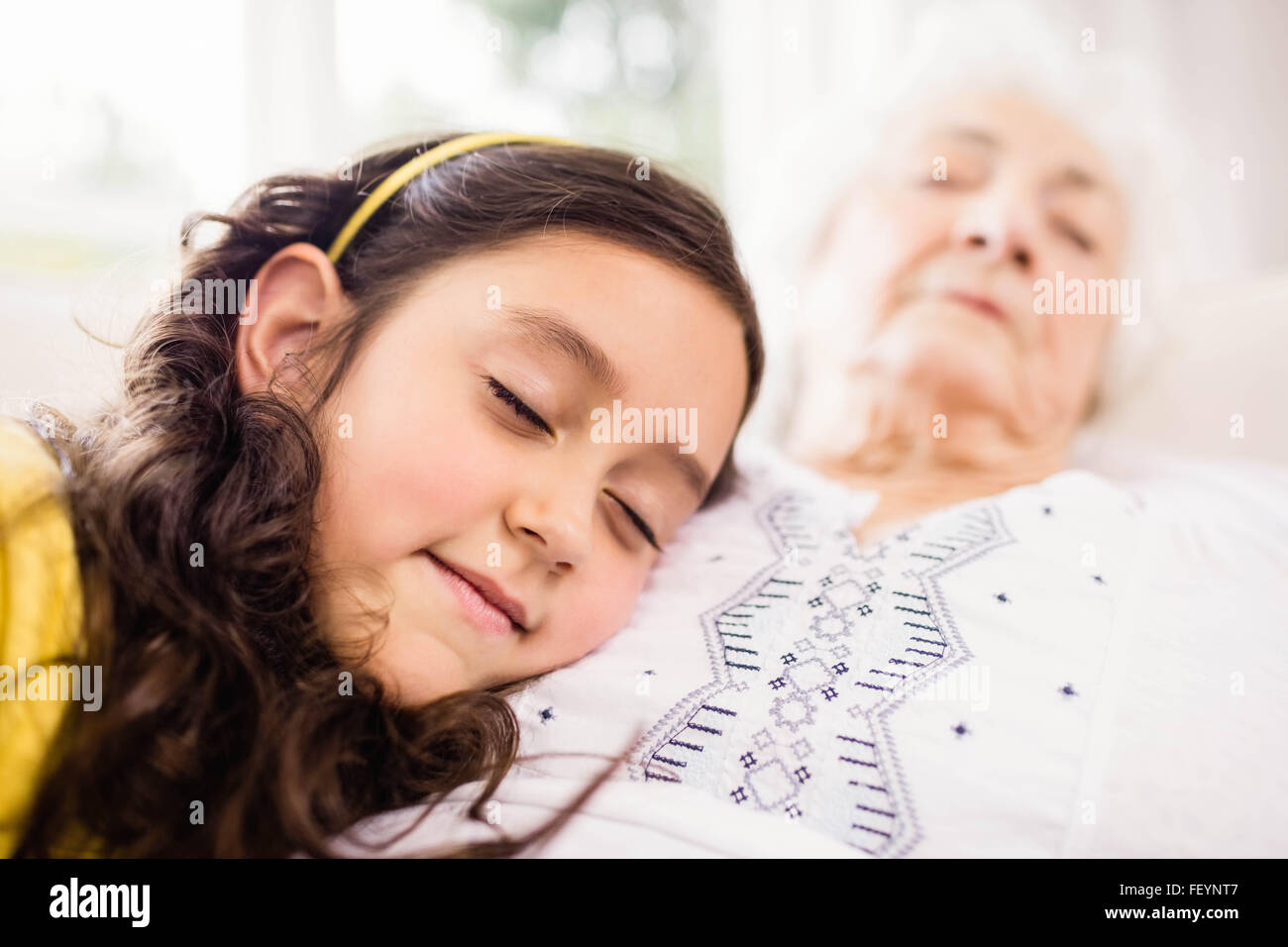 Relaxed granddaughter and grandmother napping Stock Photo