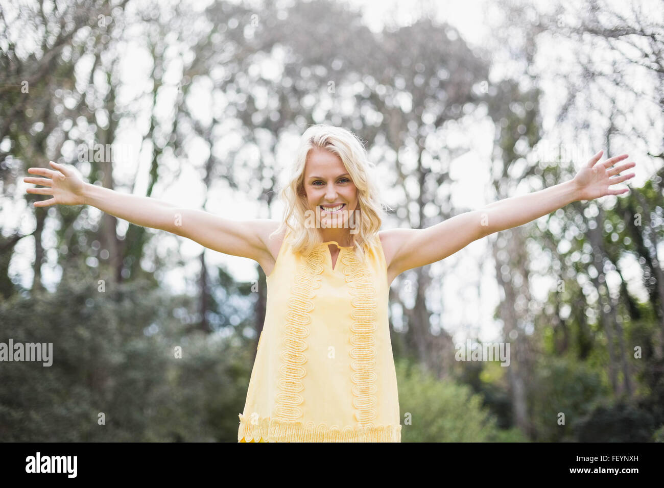 Happy woman with arms raised Stock Photo