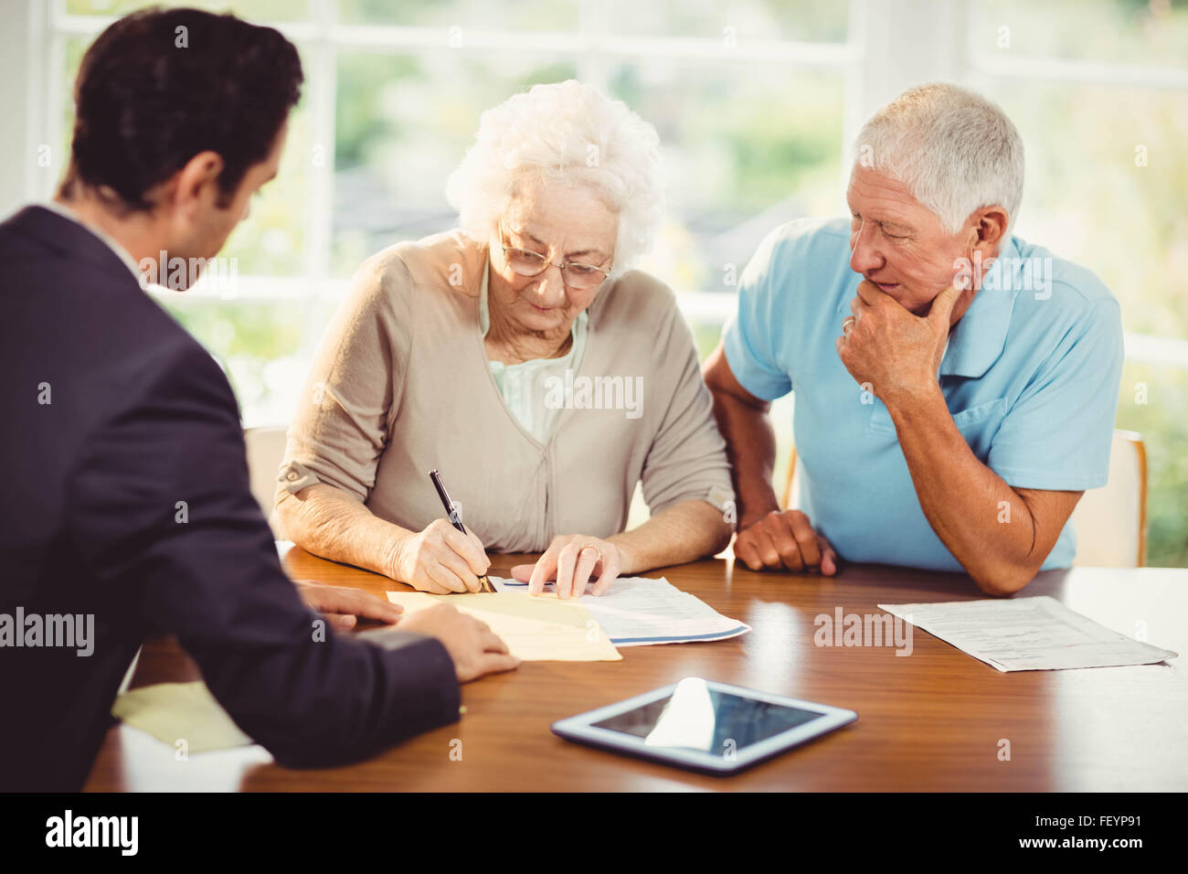 Senior woman signing document Stock Photo