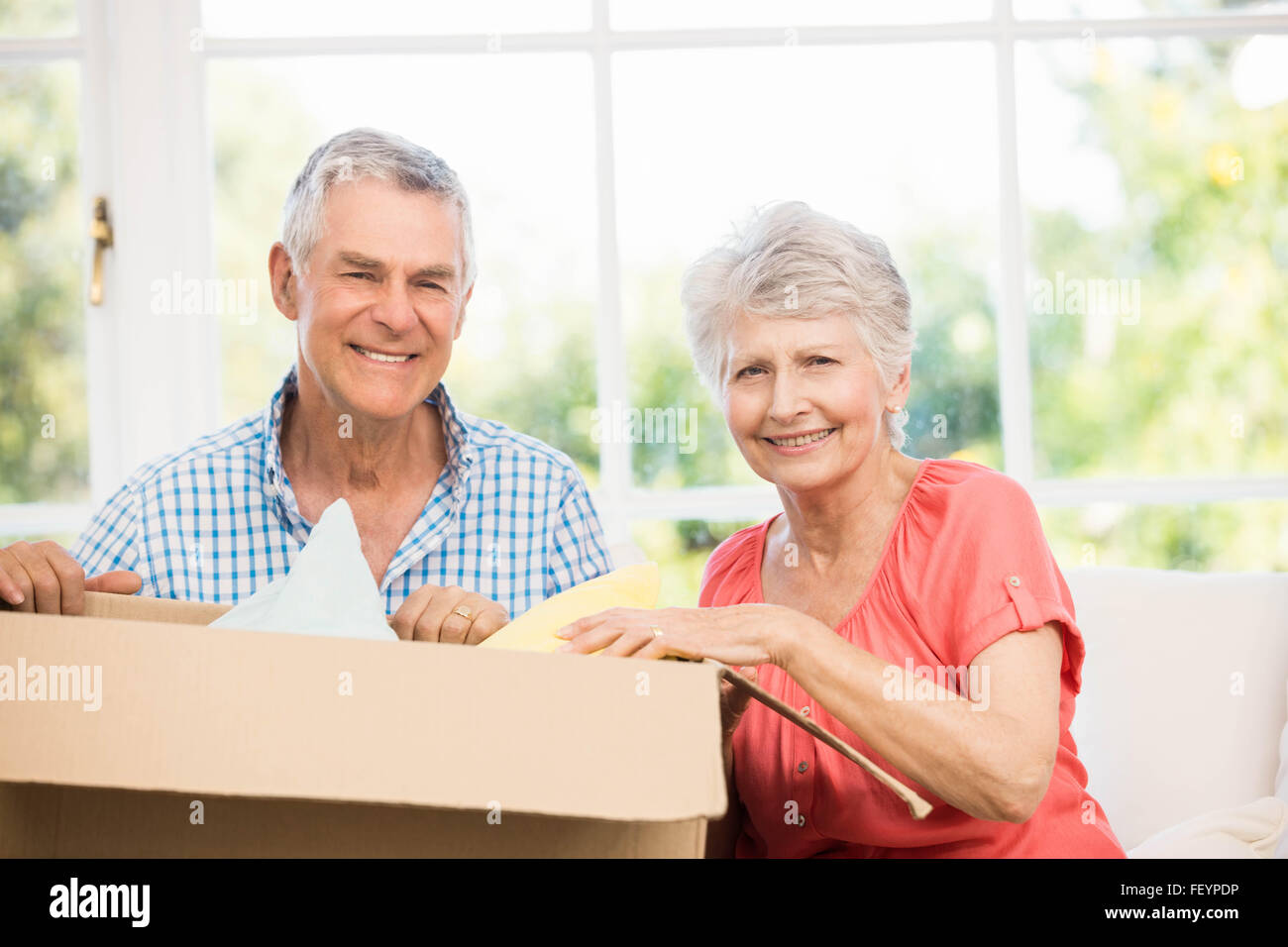 Senior couple opening big box Stock Photo