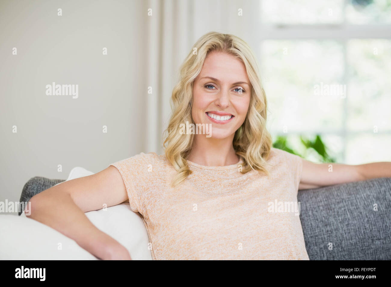 Pretty woman sitting on her couch Stock Photo