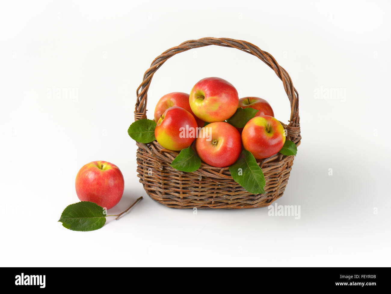 basket of red apples with leaves on white background Stock Photo Alamy