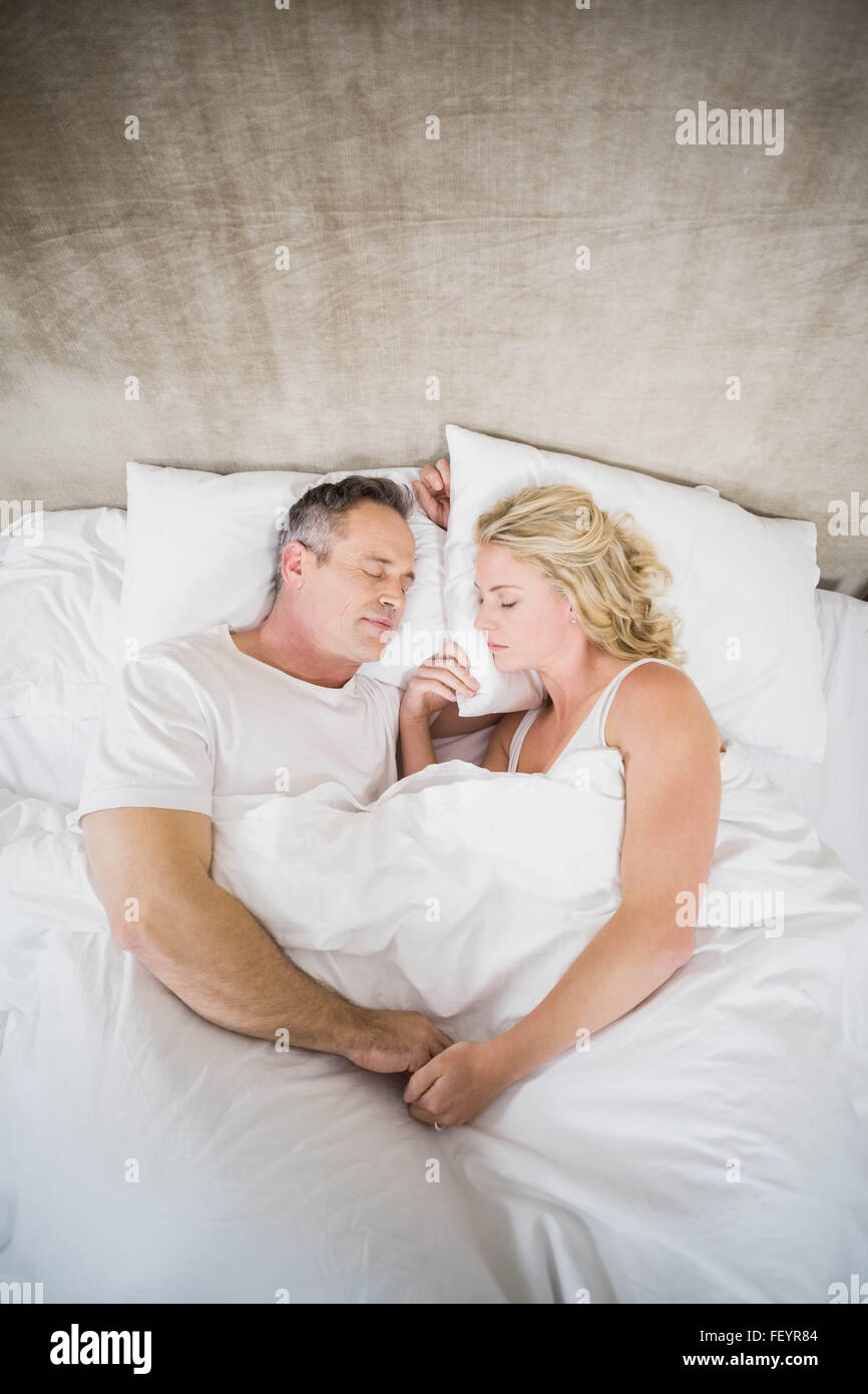 Cute couple sleeping in their bed Stock Photo