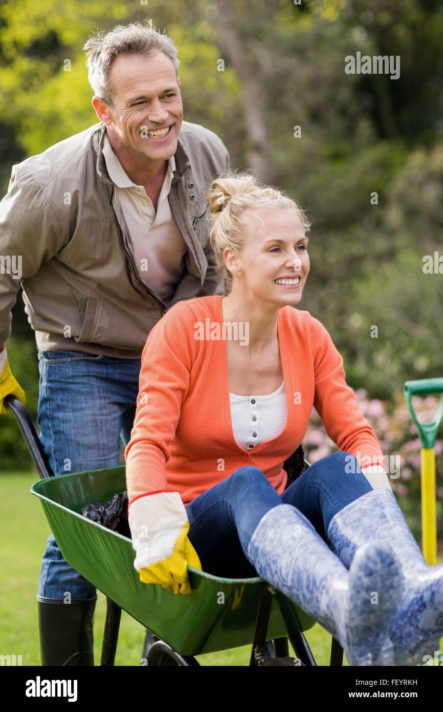 Husband pushing wife in a wheelbarrow Stock Photo