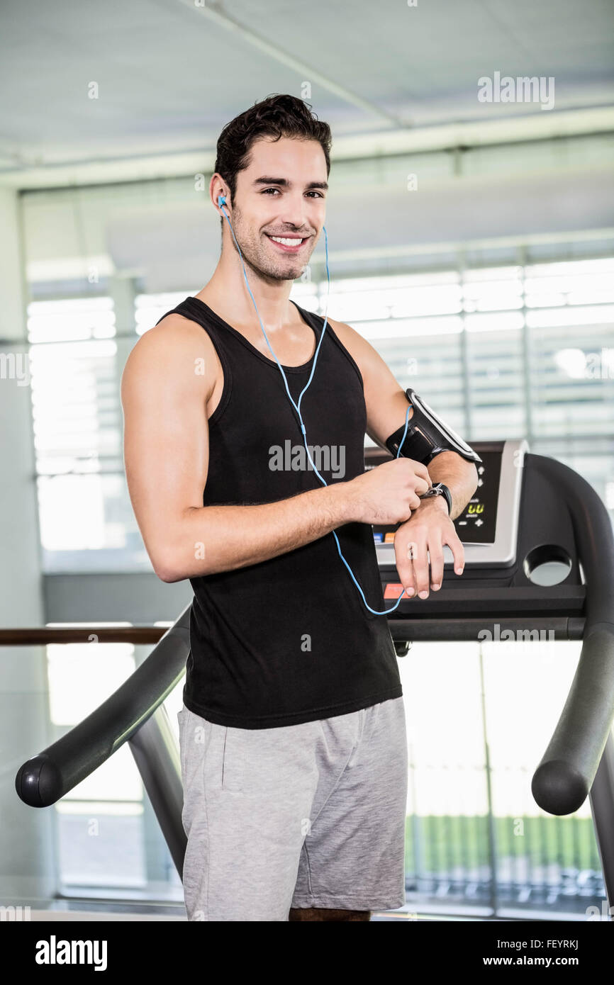 Smiling man on treadmill using smart watch Stock Photo - Alamy