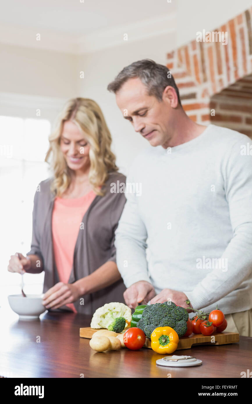 Cute couple slicing vegetables Stock Photo