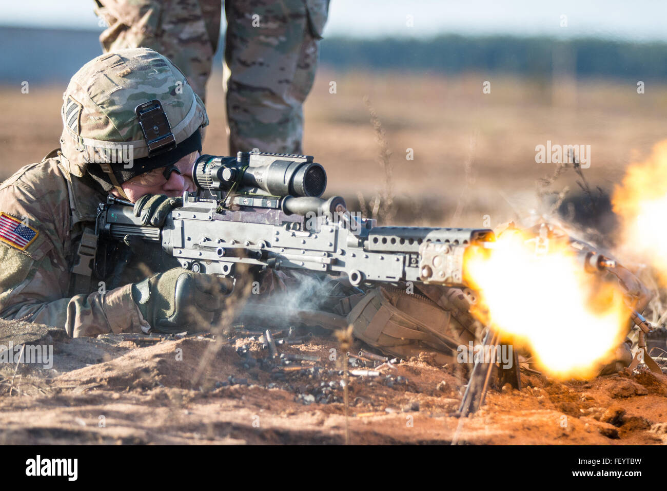 Spc. Timmy Racke, an infantryman with the 3rd Battalion, 69th Armor Regiment, 1st Armor Brigade Combat Team, 3rd Infantry Division, engages targets with his M240B Machine Gun while conducting battle drills Dec. 2, 2015 at Pabrade Training Area, Lithuania. The battle drills allowed Soldiers the opportunity to fine-tune their skills within their squad and platoon. Stock Photo