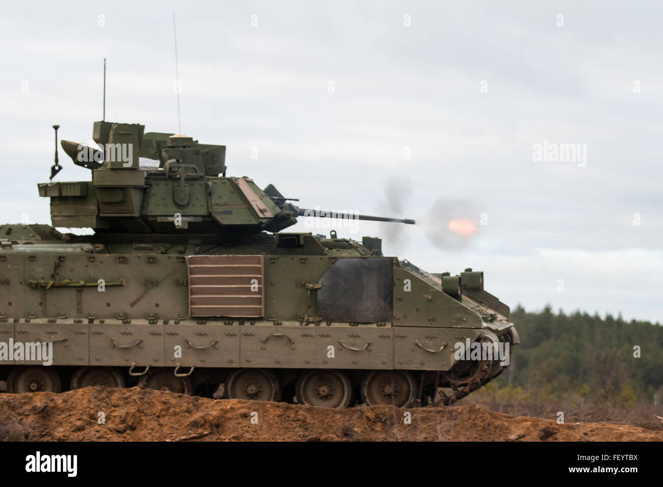 A Bradley Fighting Vehicle belonging to the 3rd Battalion, 69th Armor Regiment, 1st Armor Brigade Combat Team, 3rd Infantry Division, engages targets during gunnery training at Pabrade Training Area, Lithuania on Dec. 2, 2015.  Battle drills and gunnery training have been a priority for Soldiers of the 3rd Bn., 69th Armor Regt. in Lithuania. Stock Photo