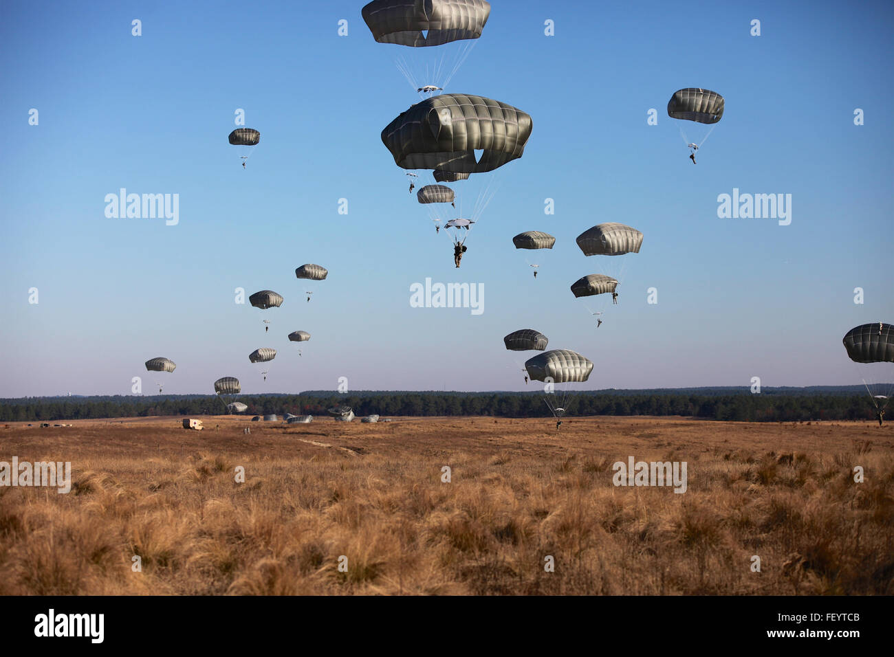 Paratroopers fill the sky at Sicily Drop Zone for the 18th Annual Randy Oler Memorial Operation Toy Drop, hosted by U.S. Army Civil Affairs & Psychological Operations Command (Airborne), Dec. 4, 2015, at Fort Bragg, N.C. Operation Toy Drop is one of the world’s largest combined airborne operations and allows soldiers the opportunity to help children in need receive toys for the holidays. Stock Photo