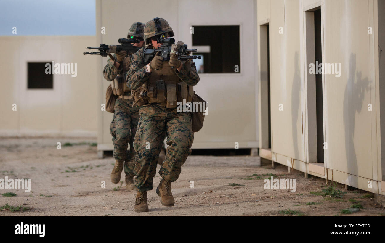 1st Battalion, 1st Marine Regiment infantrymen tactically move from building to building in a simulated combat zone during Exercise Steel Knight 2016 at Marine Corps Base Camp Pendleton, Calif., Dec. 4, 2015. 1st Marine Division has conducted Steel Knight for the past three years, making this the fourth iteration of the exercise. Steel Knight will test I Marine Expeditionary Force’s amphibious capabilities through realistic, scenario-driven training. Stock Photo