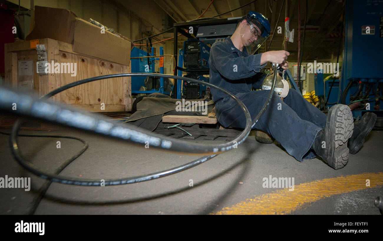 SAN DIEGO (Jan. 12, 2016) Damage Controlman 3rd Class Garrett Knight refills a self-contained breathing apparatus in the aircraft carrier USS Carl Vinson (CVN 70) hangar bay. Carl Vinson is currently undergoing a Chief of Naval Operations Planned Incremental Availability period in its homeport of San Diego. Stock Photo