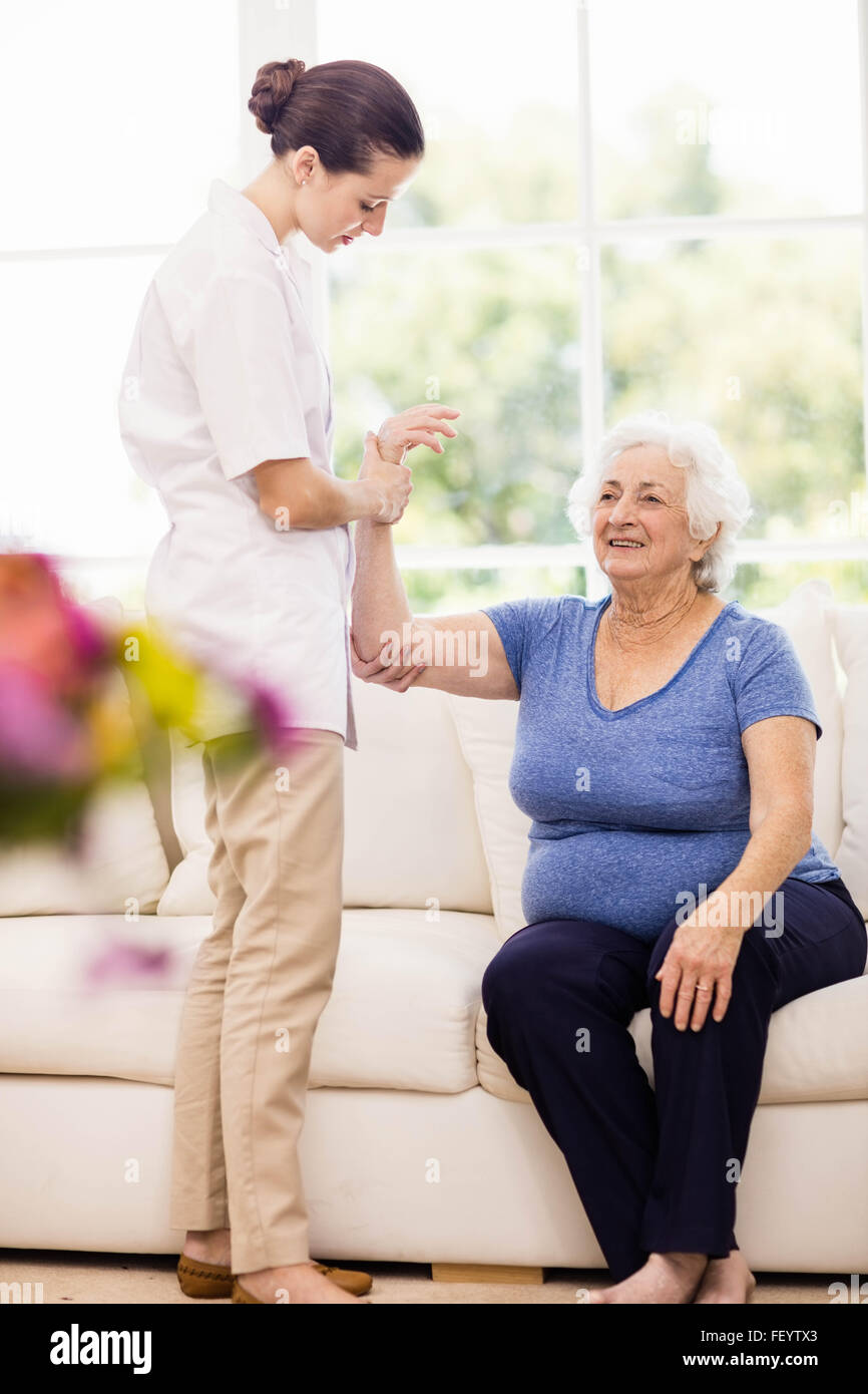 Physiotherapist taking care of sick elderly patient Stock Photo