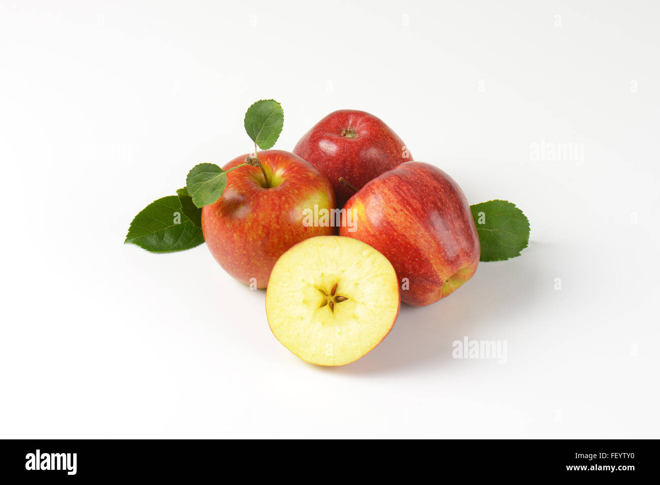 three and half apples with leaves on white background Stock Photo