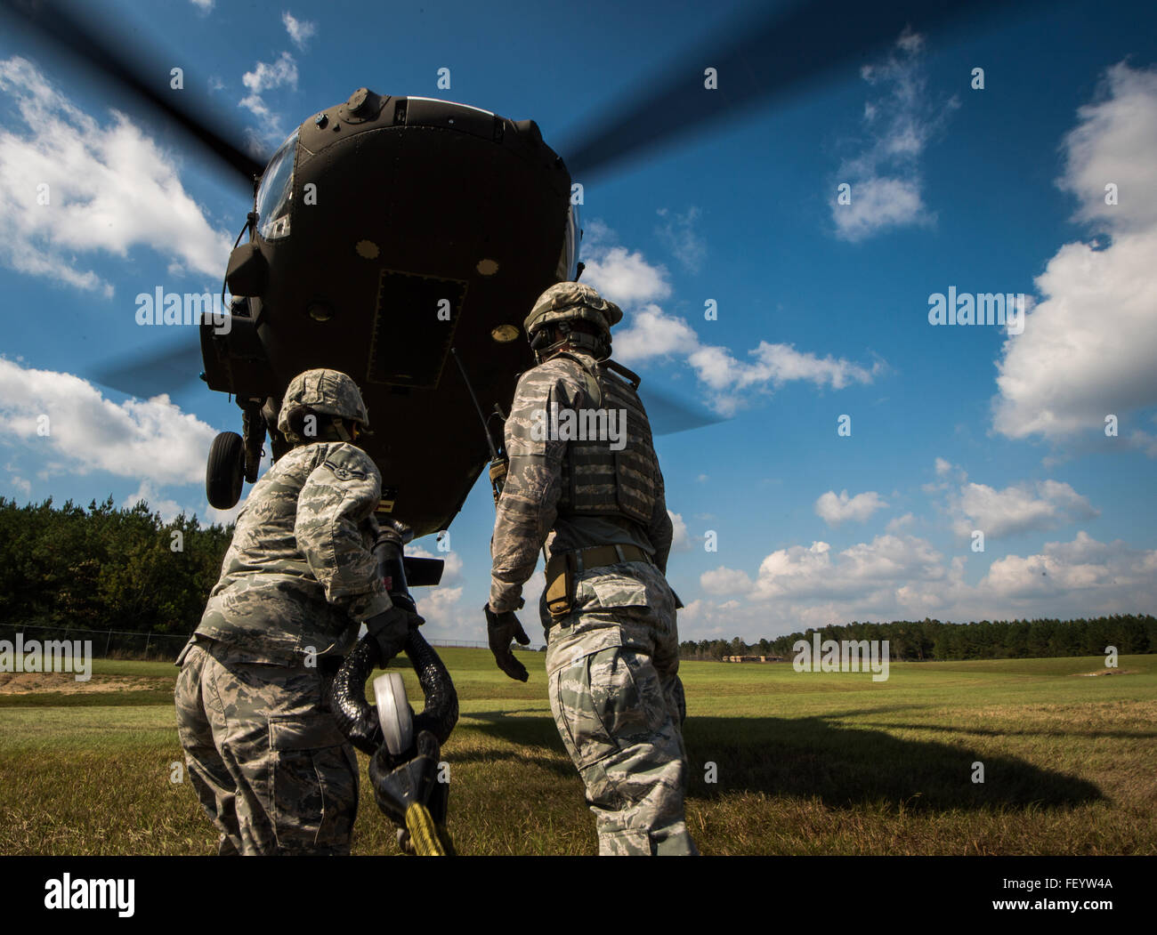 U.S. Air Force Airmen from the 321st Contingency Response Squadron from Joint Base McGuire-Dix-Lake Hurst, N.J., try to attach a sling load to a Mississippi Army National Guard Medical Evacuation UH-60 Black Hawk helicopter at Camp Shelby Joint Forces Training Center, Miss., during Exercise Turbo Distribution, Oct. 29, 2015. The U.S. Transportation Command exercise tests the Joint Task Force Port-Opening's ability to deliver and distribute cargo during humanitarian relief operations. Stock Photo