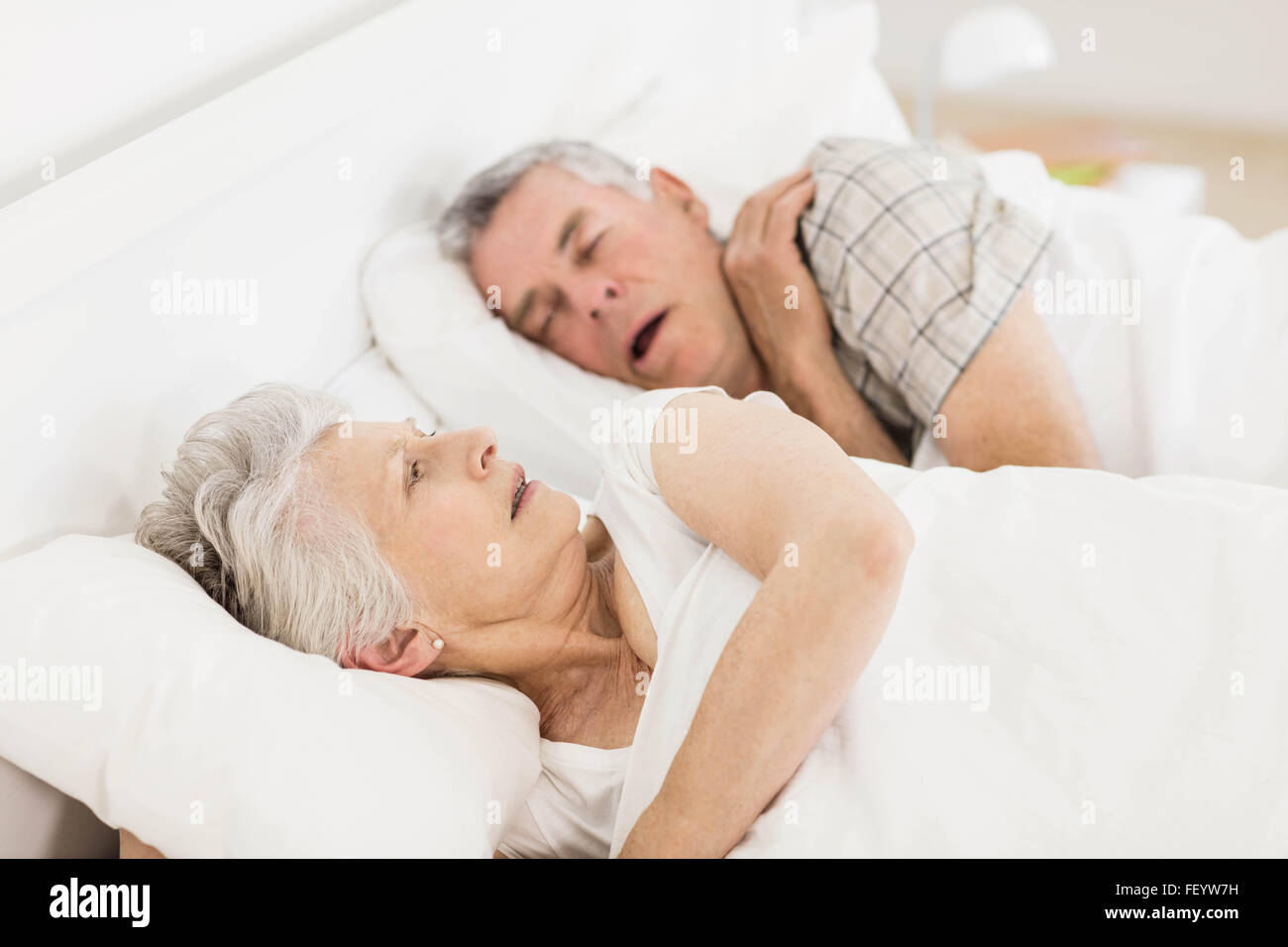 Awake senior woman in bed Stock Photo