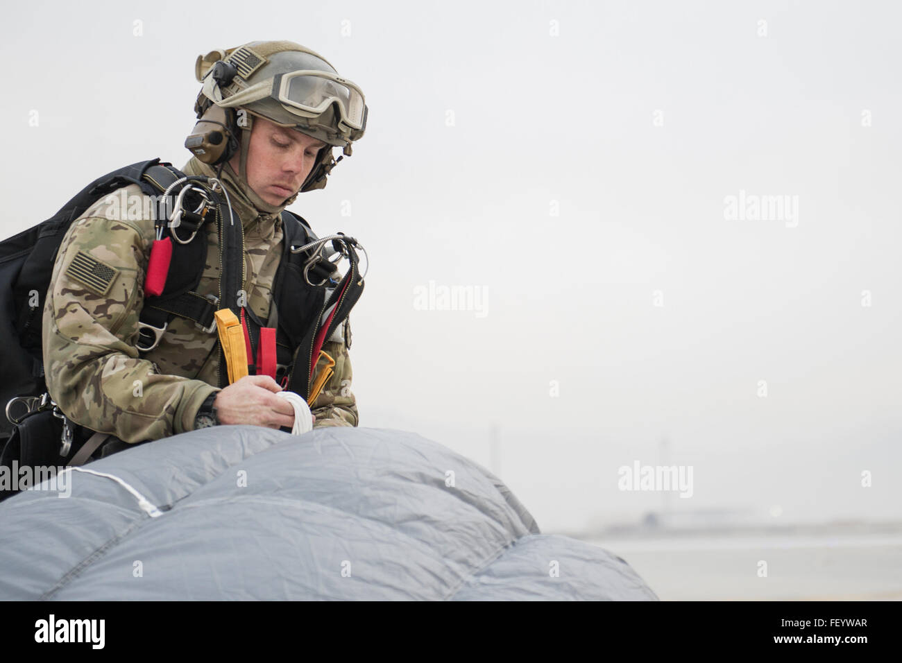 Senior Airman Josiah Stromstad, 83rd Expeditionary Rescue Squadron pararescueman, packs his parachute after jumping from an HH-60 Pave Hawk over Bagram Air Field, Afghanistan, Nov. 22, 2015. The team jumps to maintain proficiency and train for their mission in support of Operation Freedom's Sentinel. ( Tech. Sgt. Robert Cloys/Released) Stock Photo