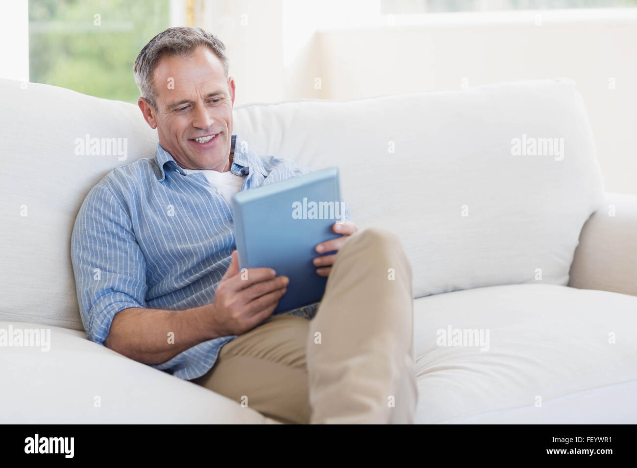 Happy man using tablet computer Stock Photo