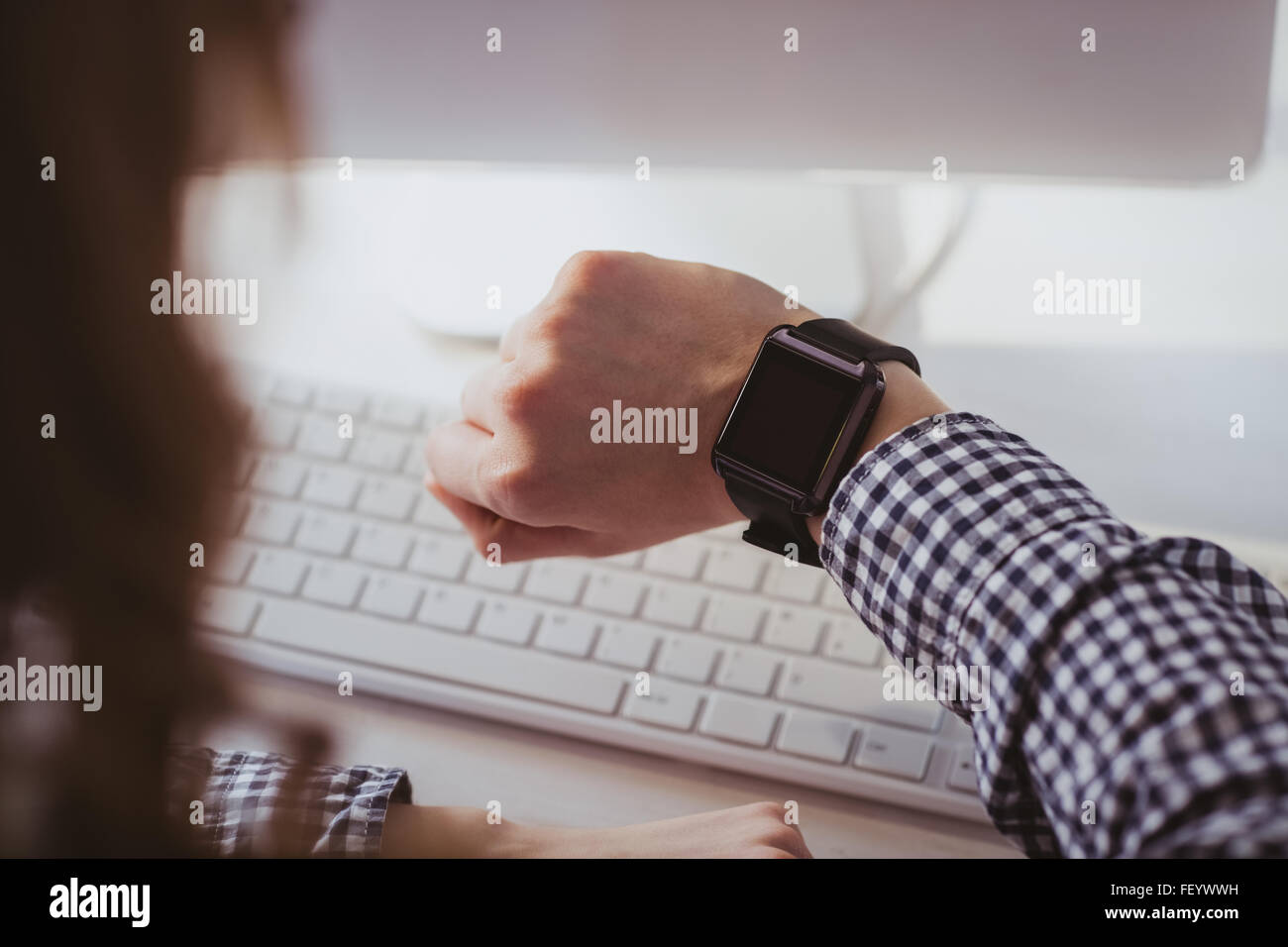 Over the shoulder view of businesswoman watching her smart watch Stock Photo