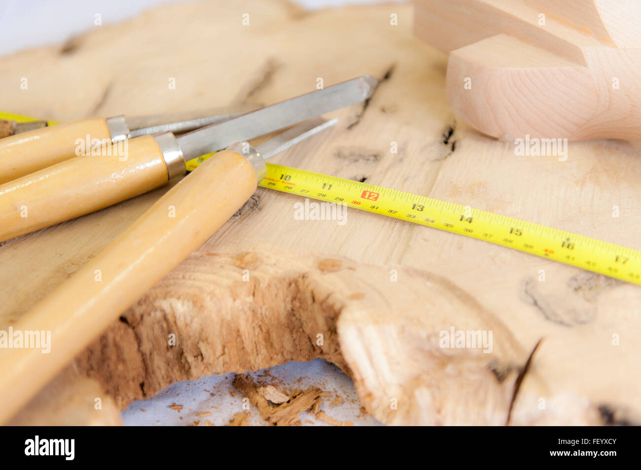 Various chisels and a steel tape measure on a piece of wood with copy space. Stock Photo