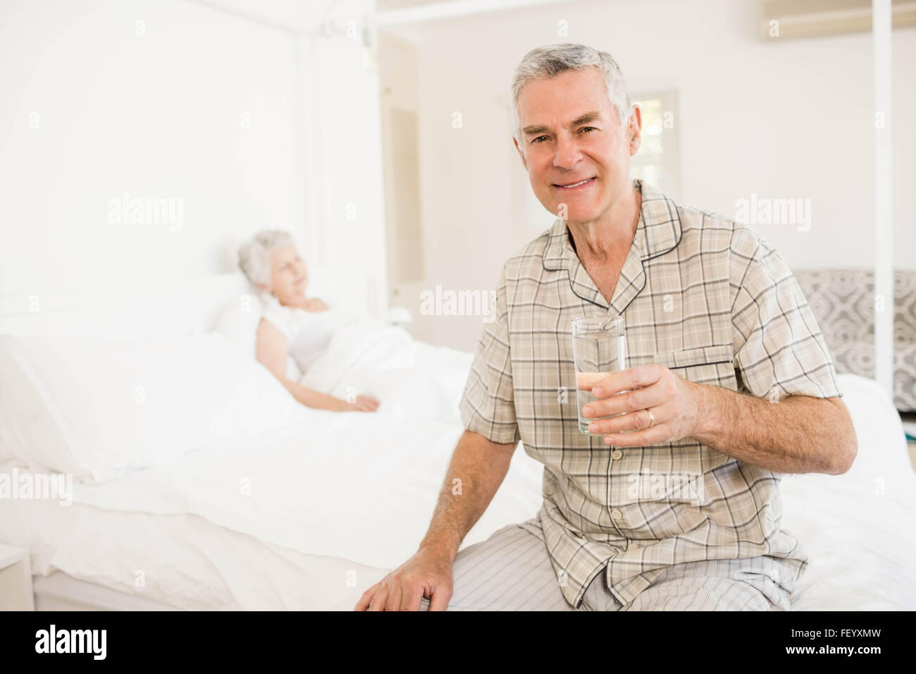 Peaceful senior man holding glass of water Stock Photo - Alamy