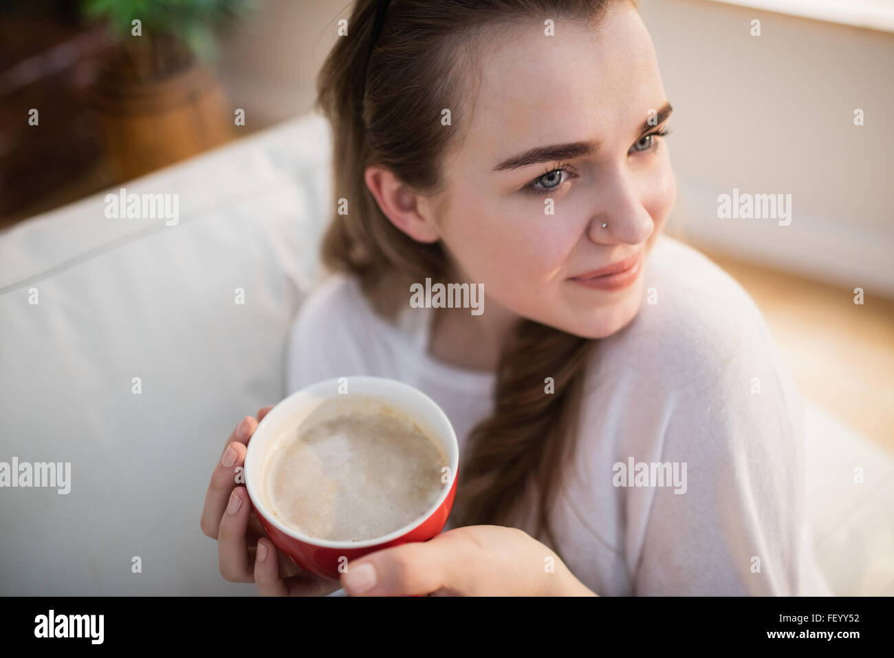 Pretty woman relaxing on couch with coffee Stock Photo - Alamy