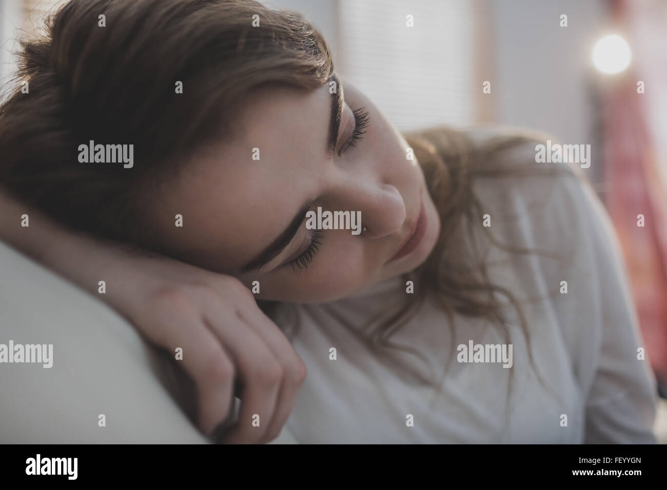 Tired woman falling asleep on the couch Stock Photo