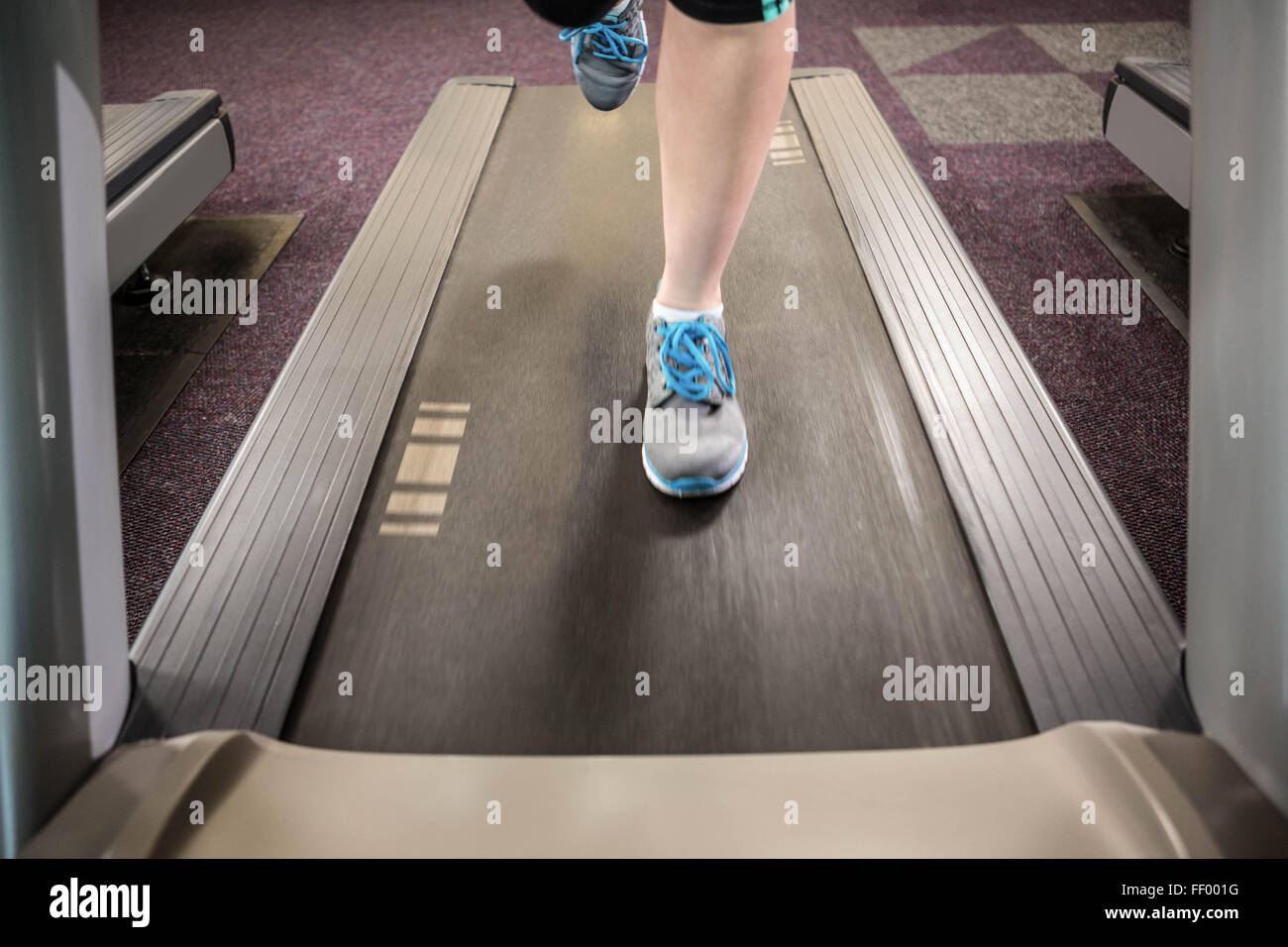 Feet of woman running on treadmill Stock Photo Alamy
