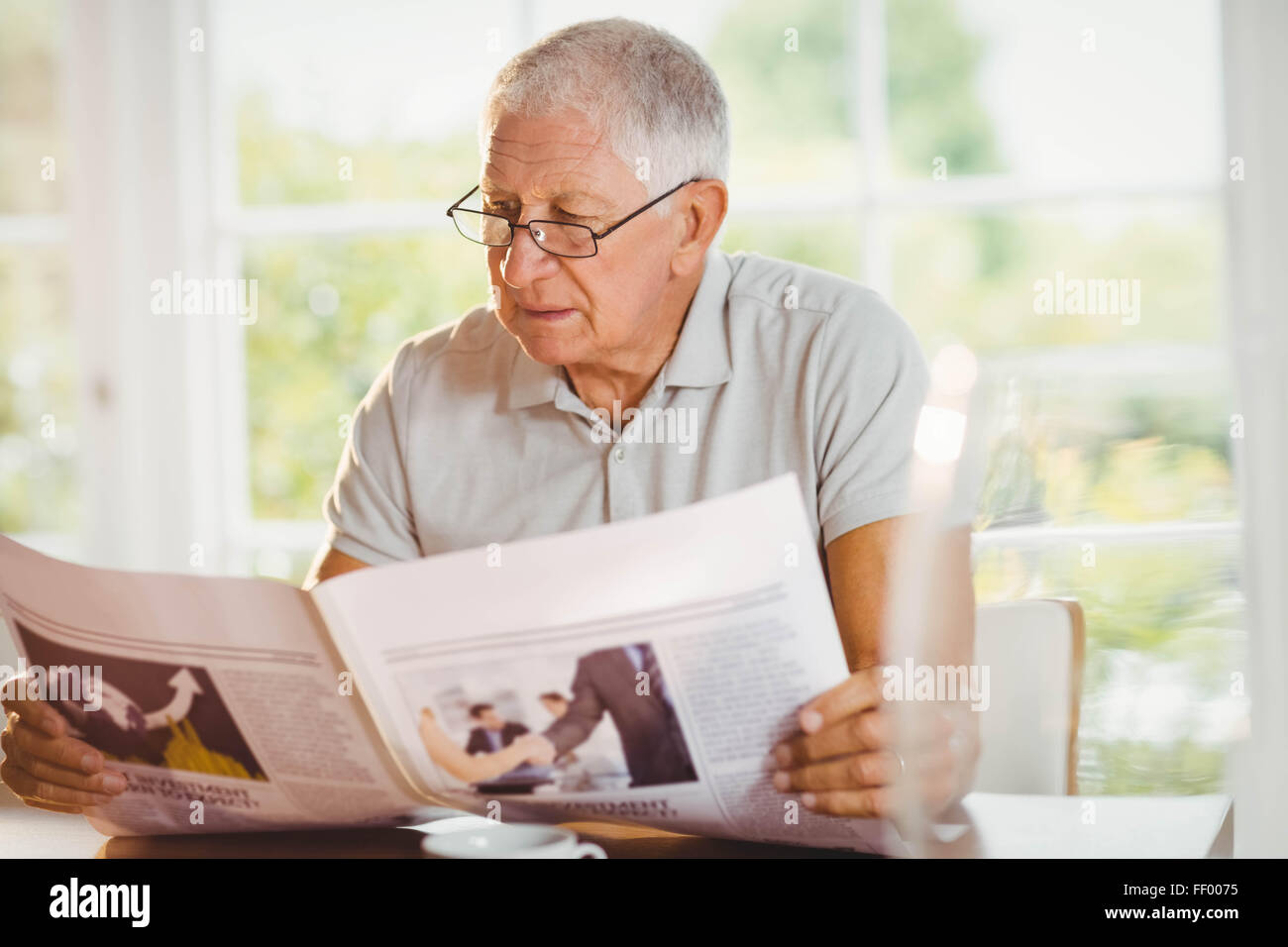 Focused senior man reading newspaper Stock Photo