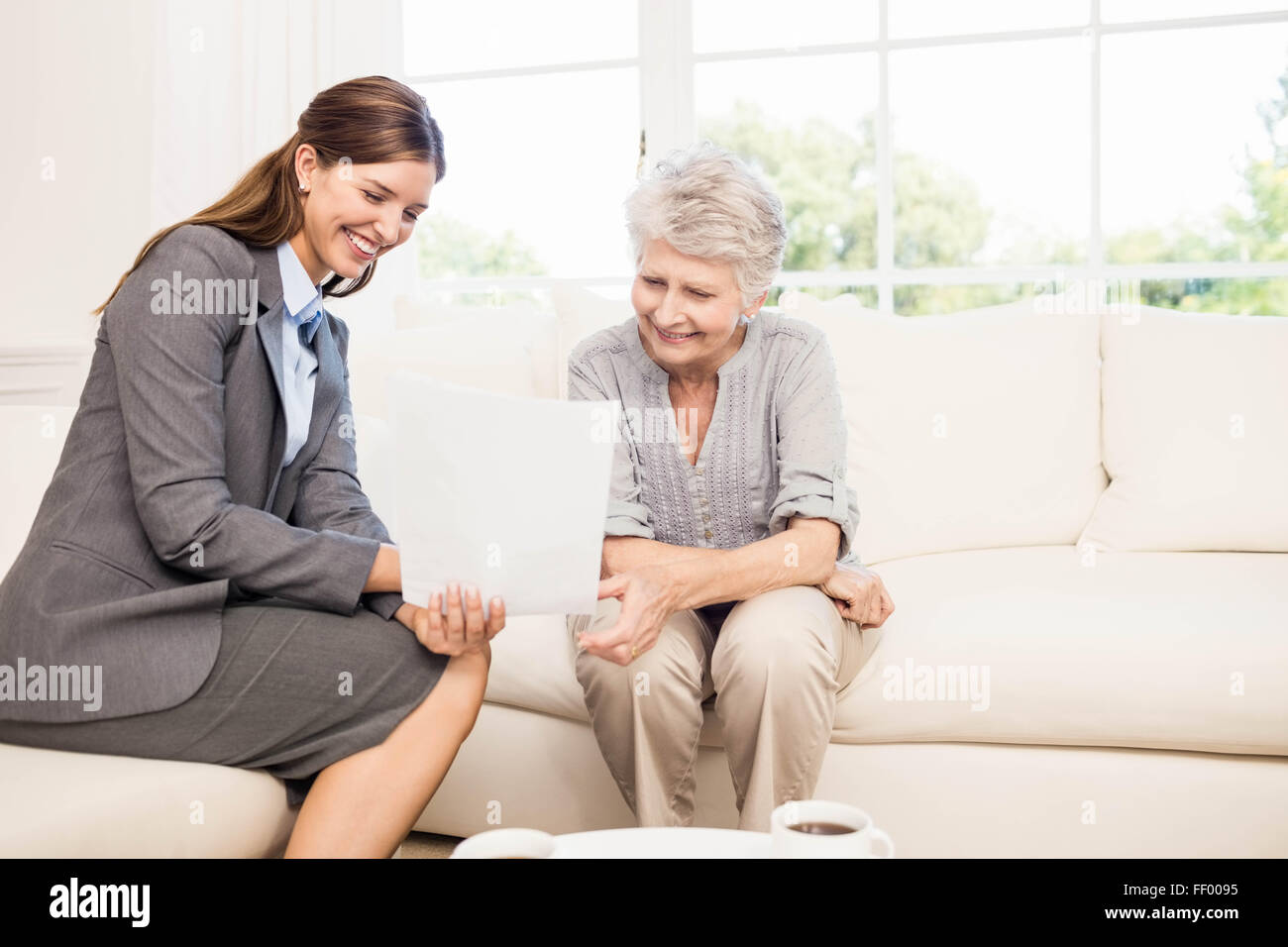 Smiling businesswoman showing documents to senior woman Stock Photo