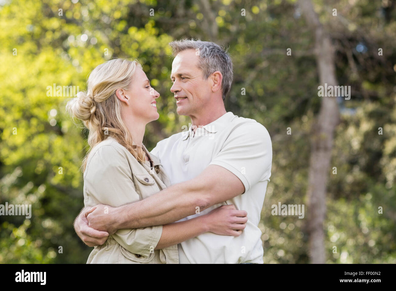 Cute couple hugging with arms around Stock Photo - Alamy