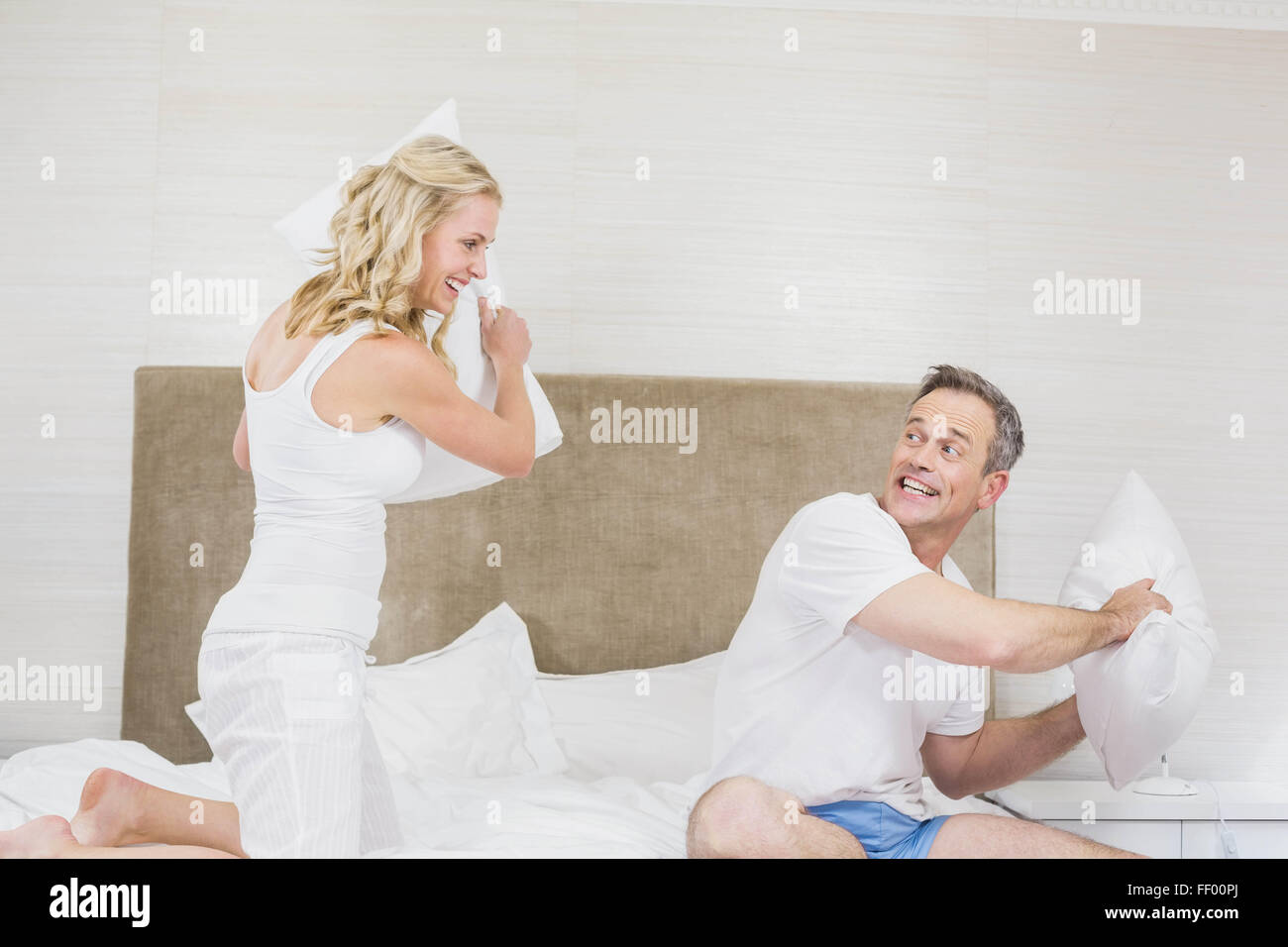 Cute couple playing pillow fight Stock Photo