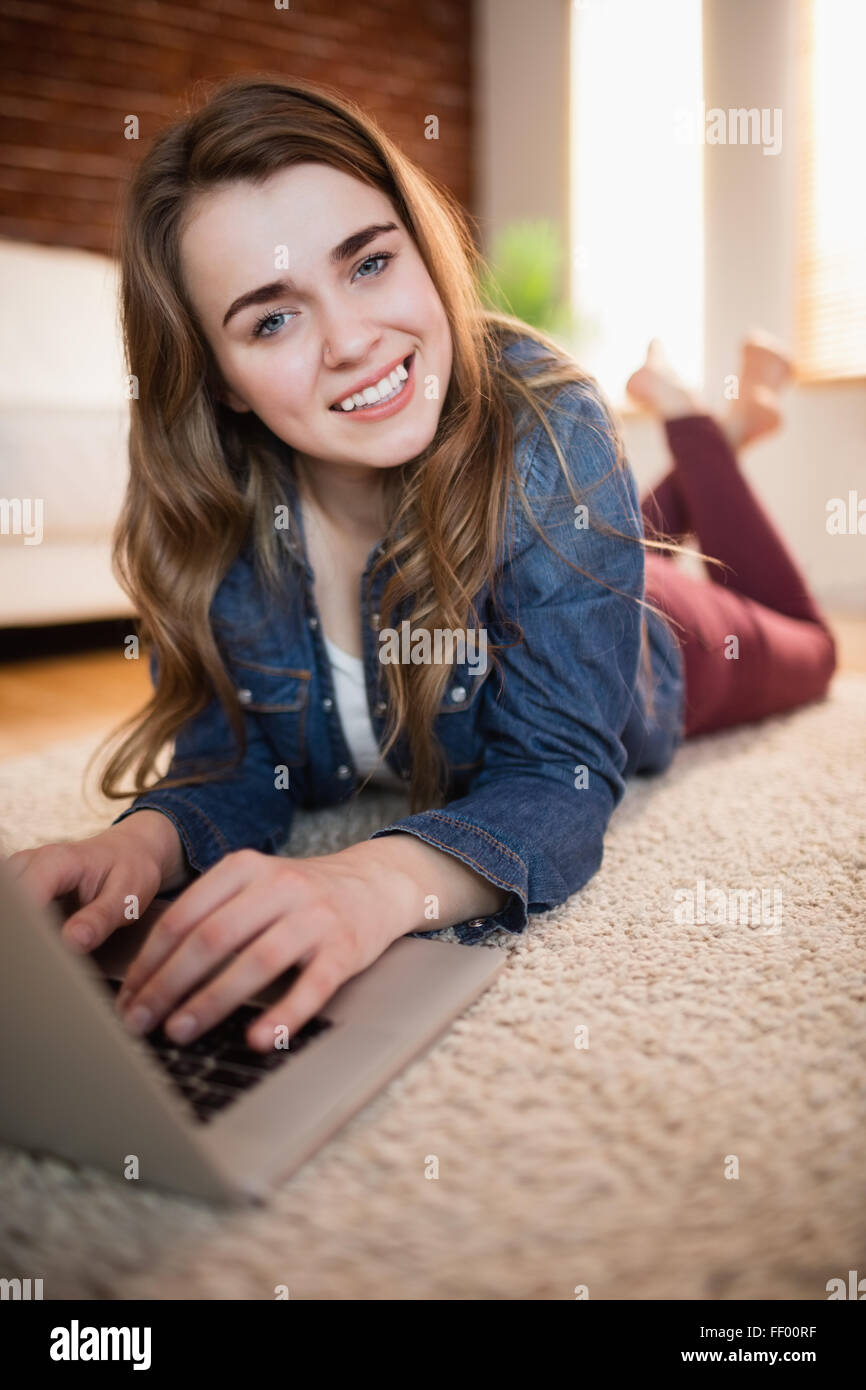 Pretty woman lying on the couch using laptop Stock Photo - Alamy