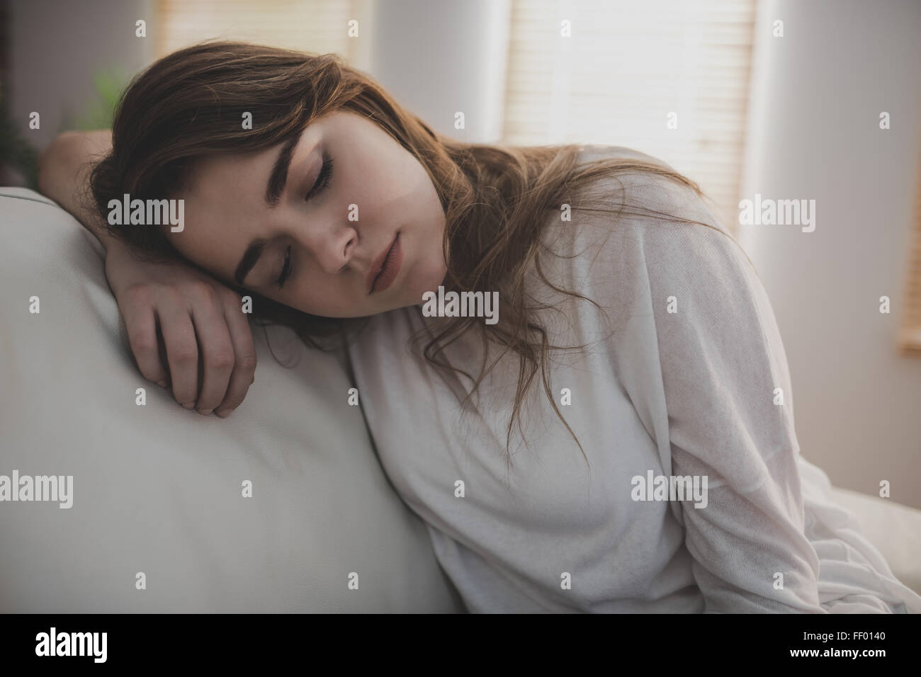 Tired woman falling asleep on the couch Stock Photo