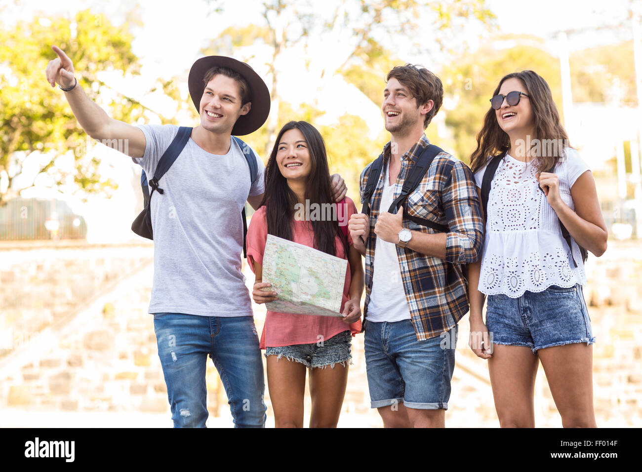 Hip friends going on a walk and checking map Stock Photo