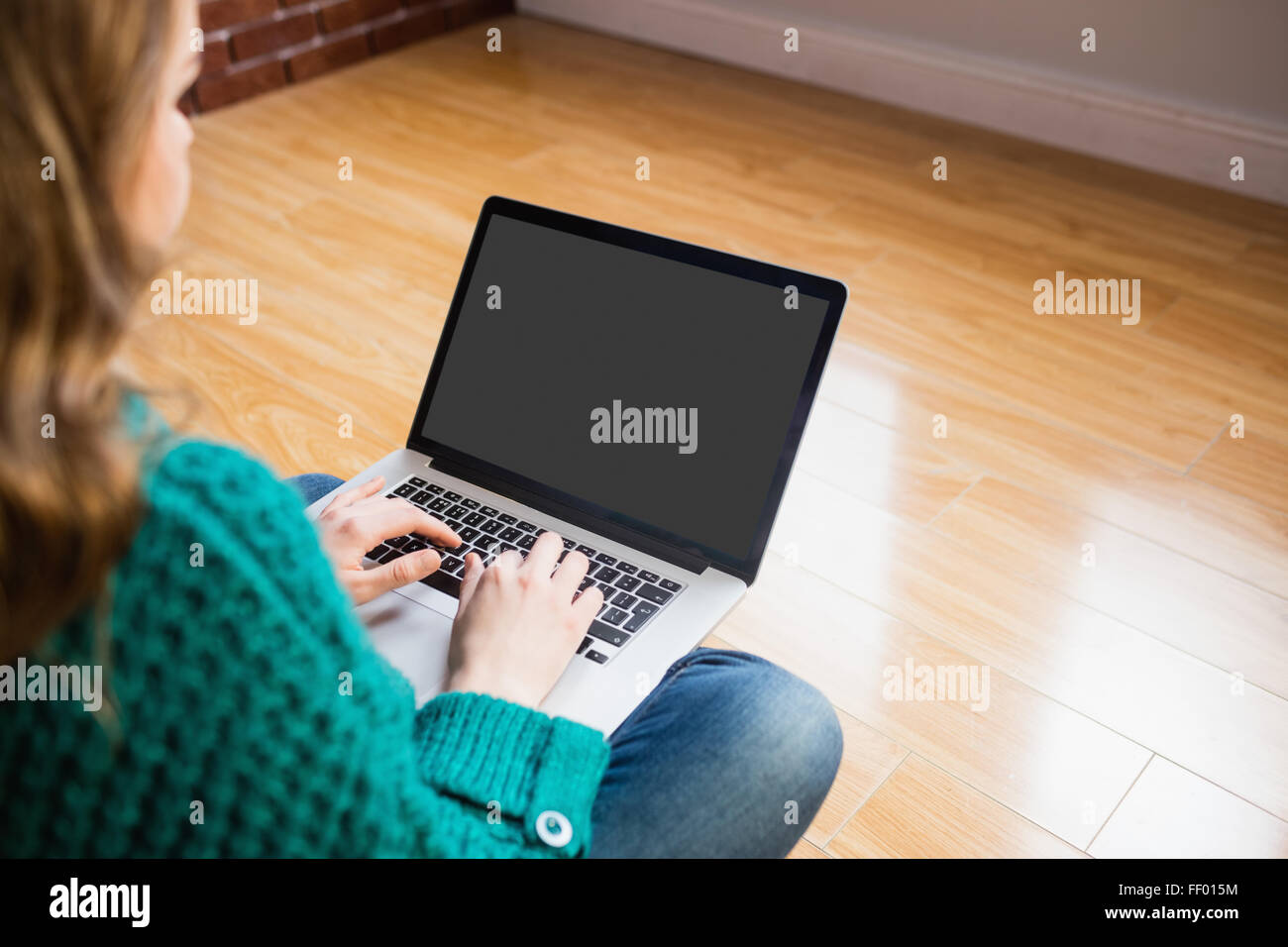 Woman sitting on the floor while using her laptop Stock Photo - Alamy