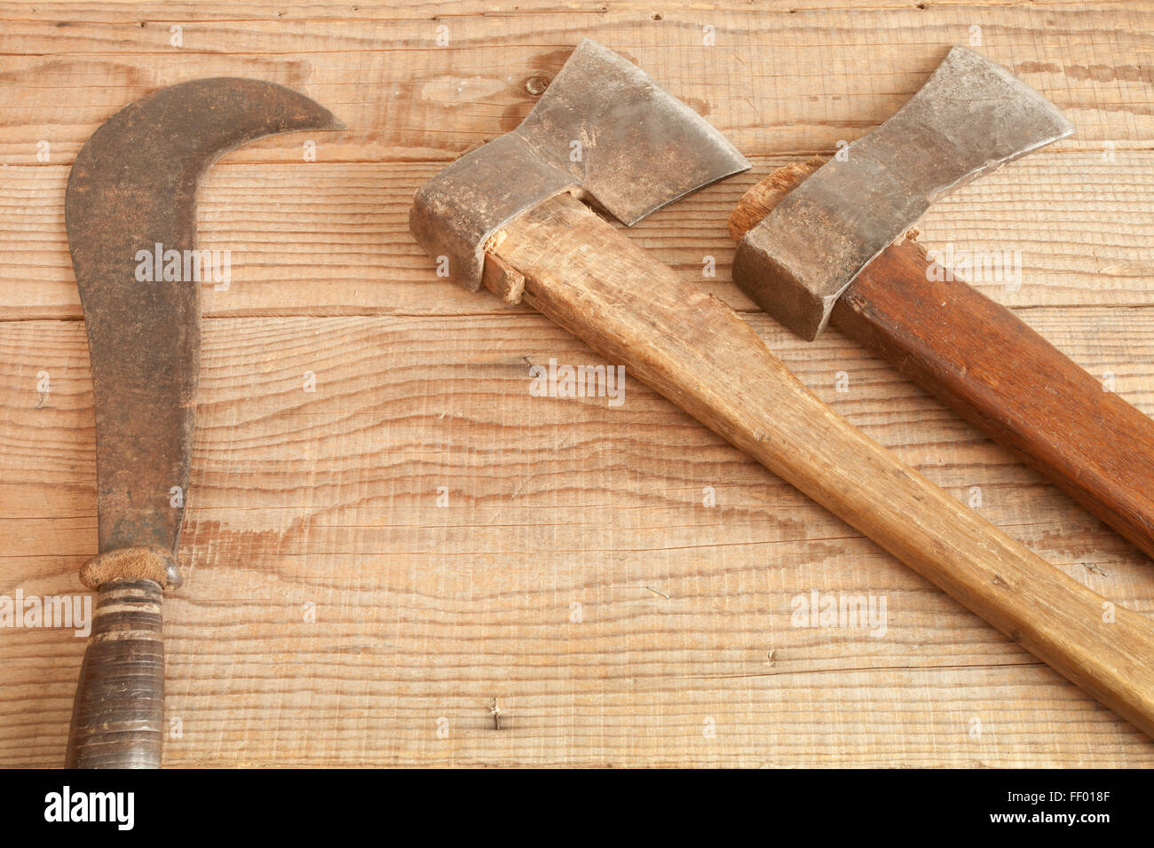 Two dated and used cleavers and billhook on wooden background Stock Photo