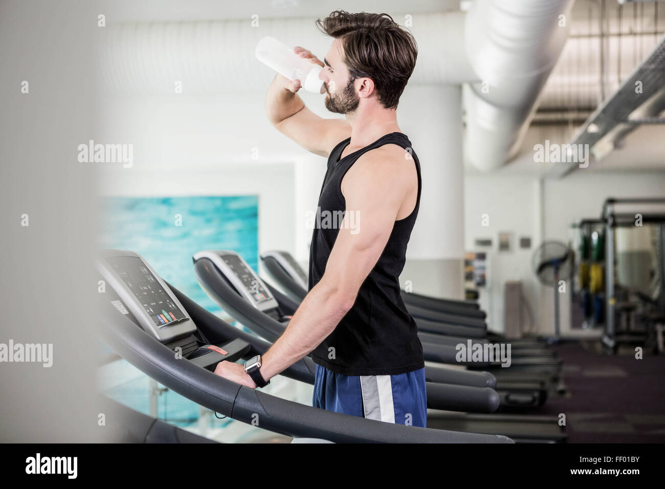 Handsome man drinking water on treadmill Stock Photo Alamy