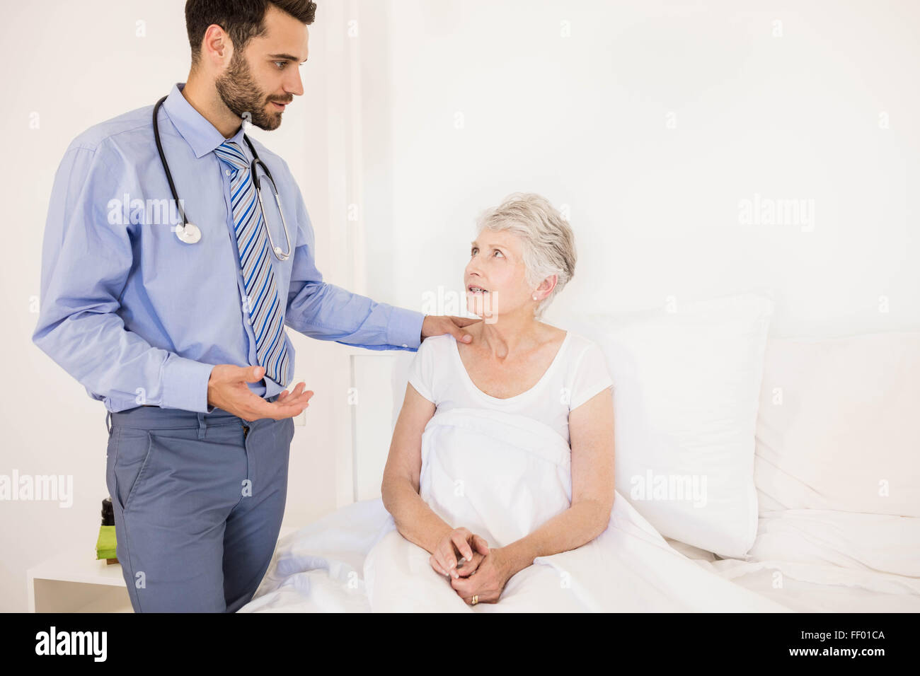 Handsome home nurse talking to elderly woman Stock Photo