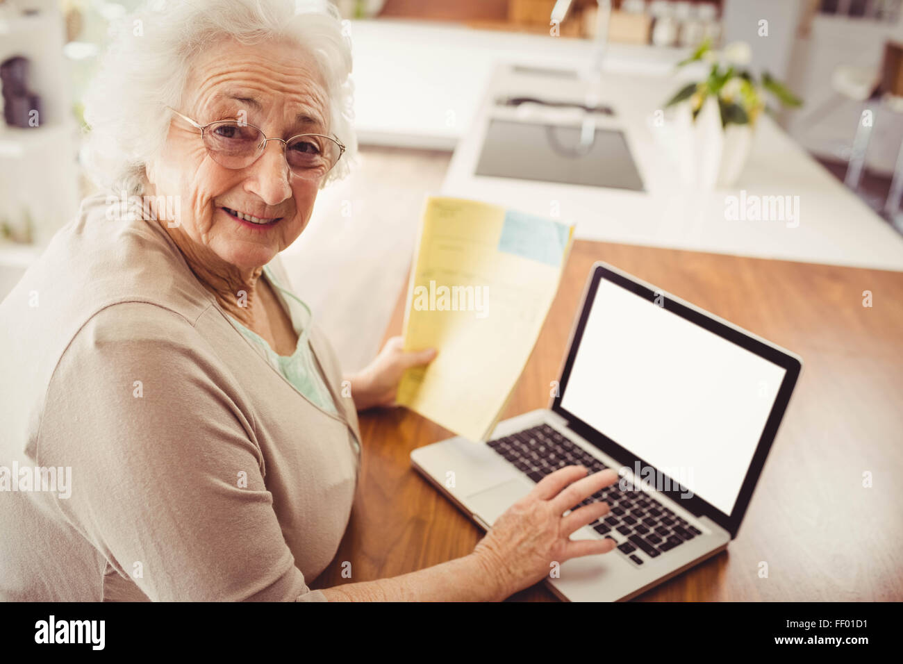Elderly woman typing on laptop Stock Photo
