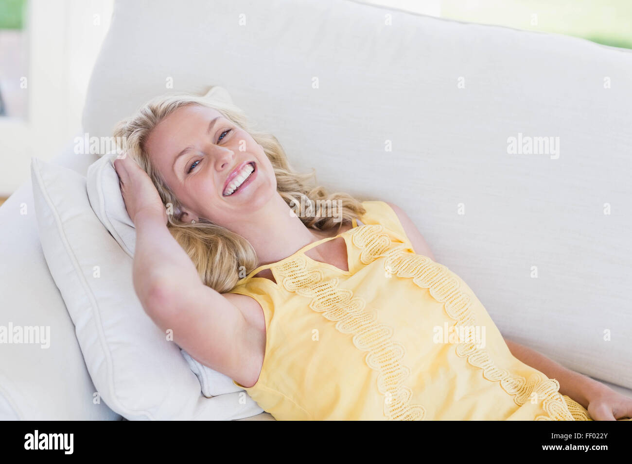 Happy woman relaxing on sofa Stock Photo