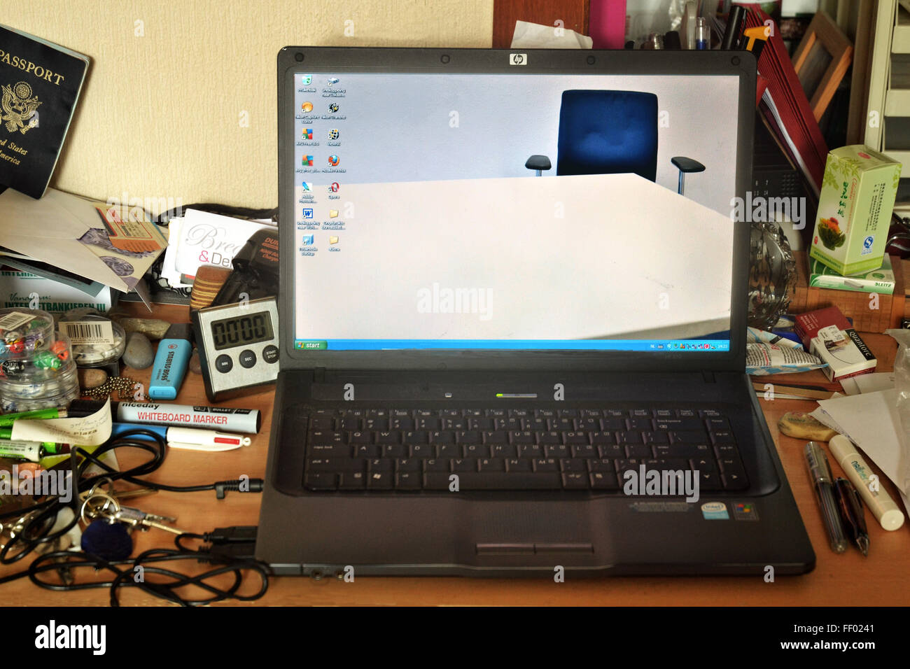 Laptop with clean desktop as screensaver lying on messy desk Stock