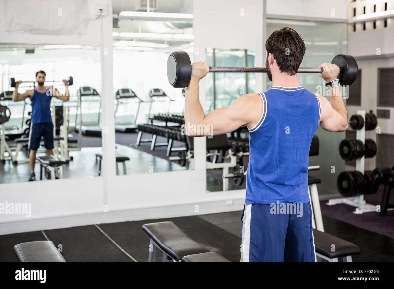 Muscular man lifting barbell Stock Photo