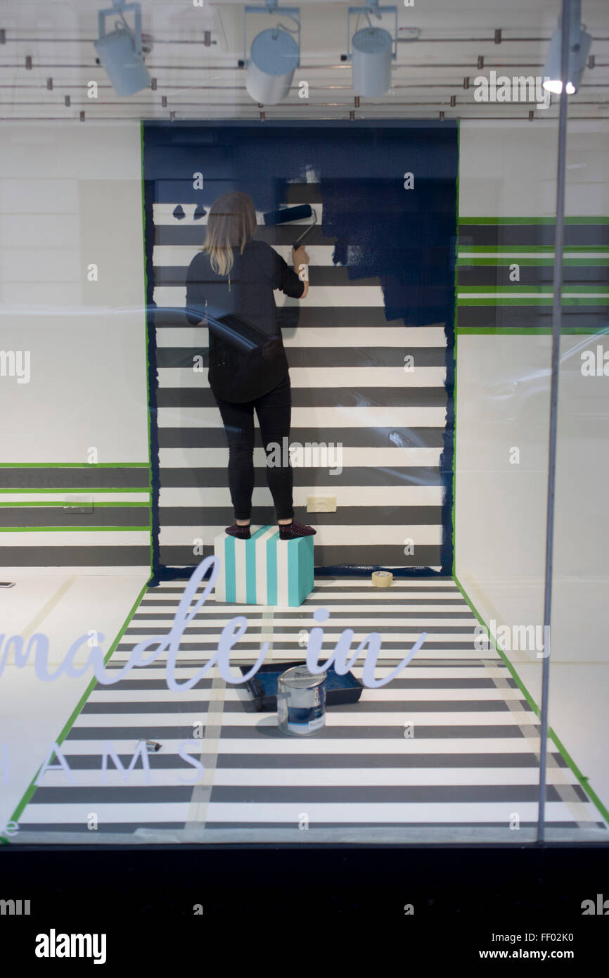 Window dressers prepare a new window design with a tripes theme in the oxford Street branch of retailer Debenhams. Stock Photo