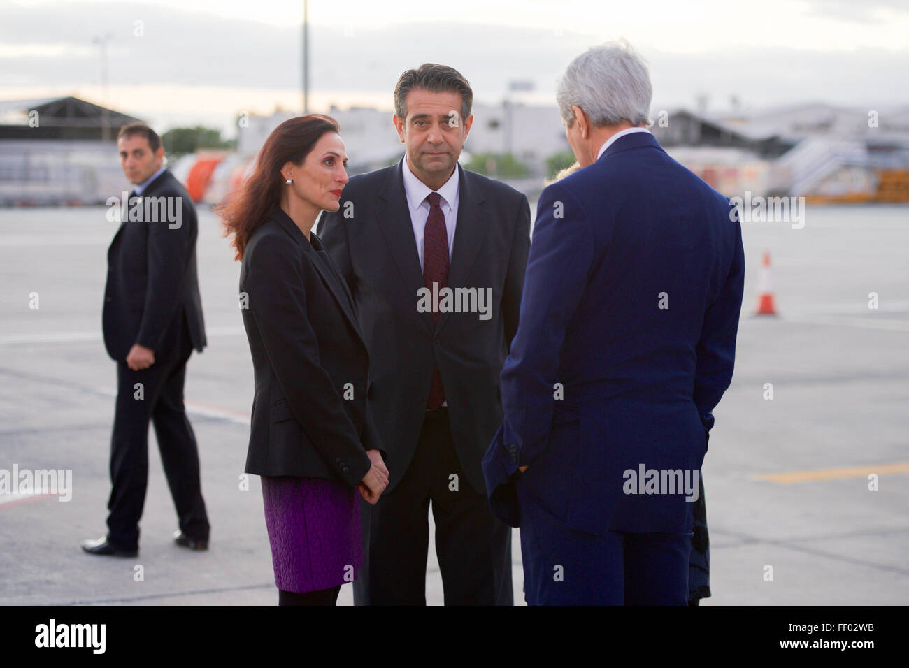 Secretary Kerry Chats With Cypriot Ministry of Foreign Affairs Chief of Protocol Kountourides and His Colleague Upon Arrival in Cyprus Stock Photo