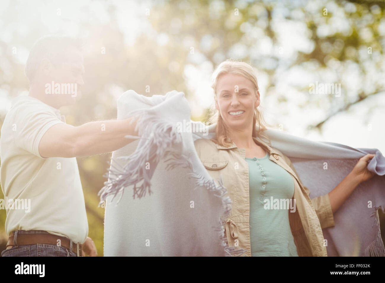 Husband putting a blanket around his wife Stock Photo Alamy