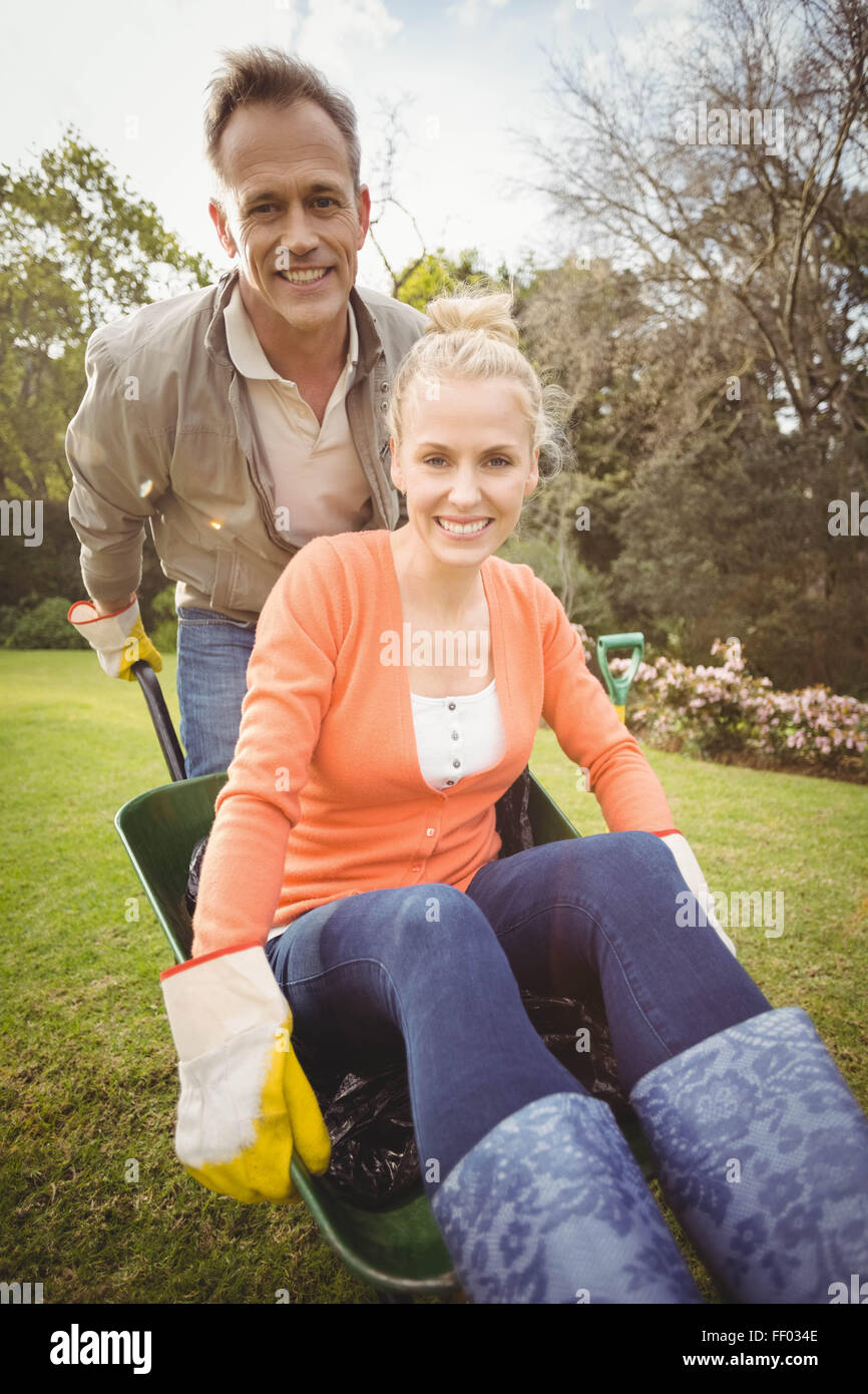 Husband pushing wife in a wheelbarrow Stock Photo